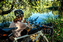 Bikepackerin mit Komoot-App auf dem Smartphone.