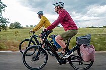 Zwei Personen fahren auf E-Bikes. 
