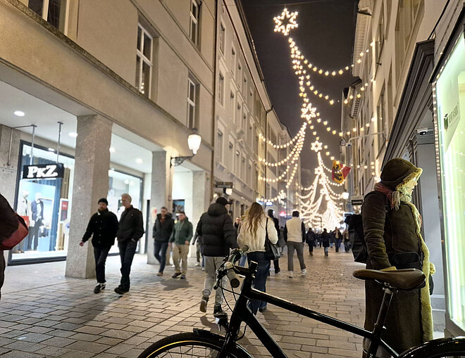 Velo in Fussgängerzone mit Weihnachtsbeleuchtung.