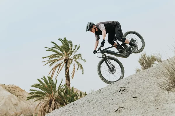 Ein Mountainbiker macht einen Stoppie mit dem E-MTB von Trek.