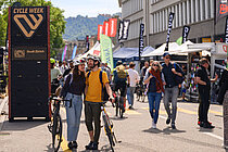 Ein Mann und eine Frau laufen händchenhaltend mit Velos auf einem Weg. 