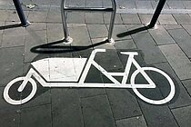 Lastenvelo auf Autoparkplatz in der Schweiz.