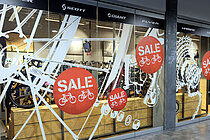 Schaufenster von Bike World mit roten SALE-Stickern.